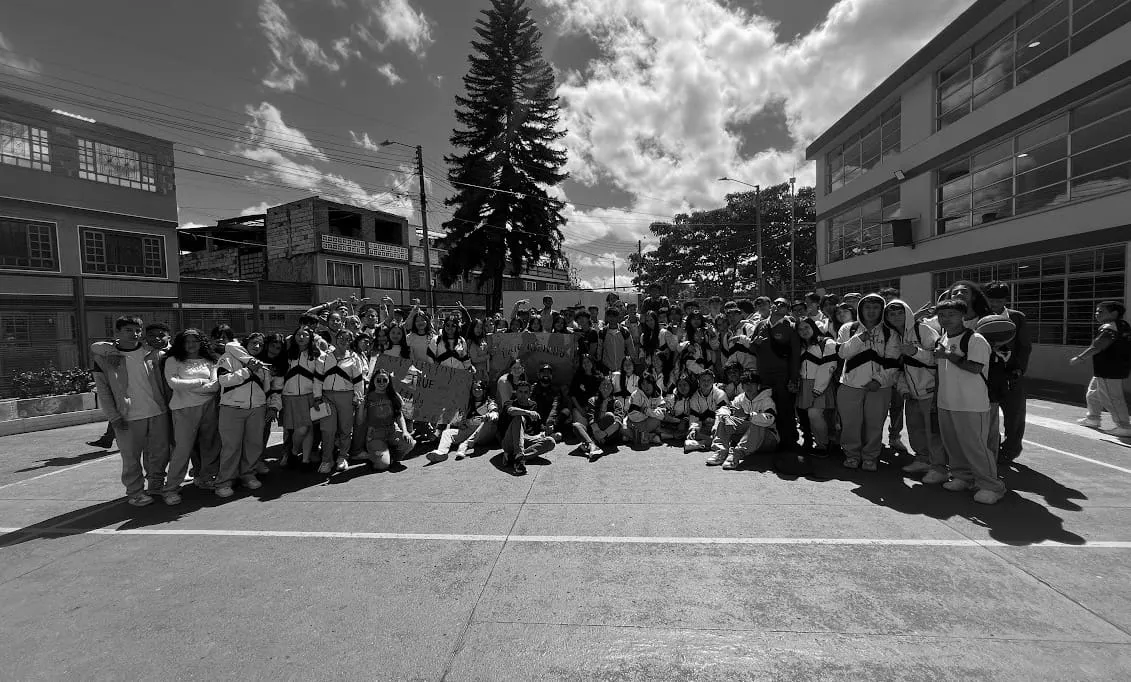 Grupo de jóvenes en un patio escolar, reunidos en comunidad